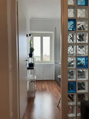 a room with a window and a glass door with a plant at Tiburtina Sky Loft in Rome
