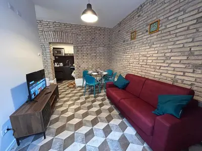 a living room with a red couch and a brick wall at Lilla a Testaccio in Rome