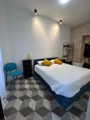 a bedroom with a large bed and a blue chair at Lilla a Testaccio in Rome