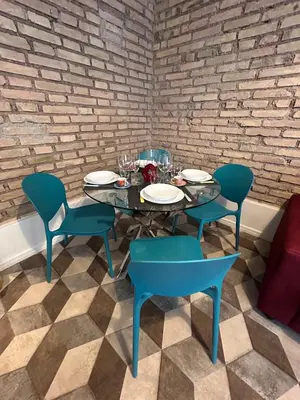 a table with four chairs and a blue table and chairs at Lilla a Testaccio in Rome
