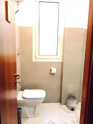 a bathroom with a toilet and a window at DOMUS REMO Room #1 in Rome