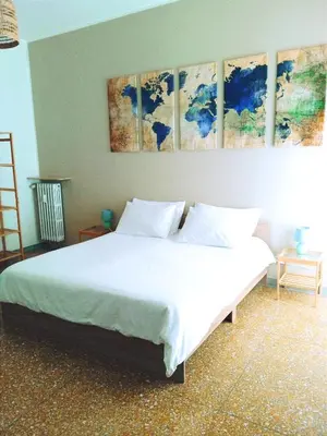 a bedroom with a white bed with four paintings on the wall at DOMUS REMO Room #1 in Rome