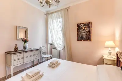 a bedroom with a bed and a dresser and a window at Casa Vacanze San Giovanni in Rome