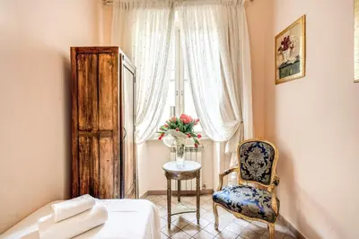 a bedroom with a bed and a chair and a window at Casa Vacanze San Giovanni in Rome