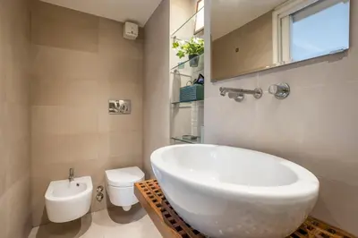 a bathroom with a white sink and a toilet at Your nest with wooden ceilings in Monti in Rome