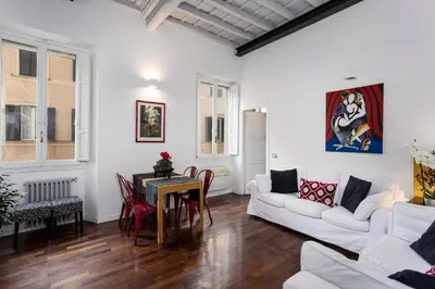a living room with a couch and a table at Your nest with wooden ceilings in Monti in Rome