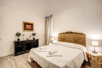 a white bedroom with two beds and a window at Casa Vacanze Crispi in Rome