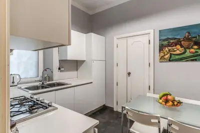 a white kitchen with a bowl of fruit on a counter at Casa Vacanze Crispi little 1 in Rome
