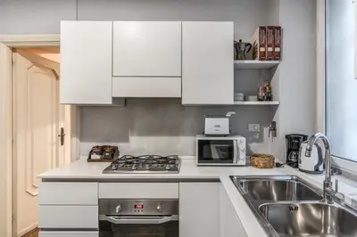 a white kitchen with a sink and a microwave at Casa Vacanze Crispi little 1 in Rome