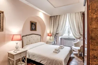 a bedroom with a white bed and a chair at Casa Vacanze Crispi little 1 in Rome