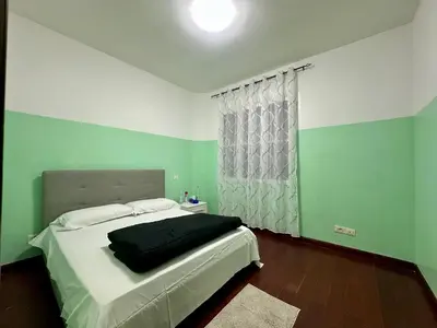 a bedroom with green and white walls and a bed at Bellaroma Astréa apartment in Rome