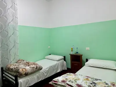 two beds in a room with blue walls at Bellaroma Astréa apartment in Rome
