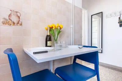 a table and chairs with a bottle of wine and flowers at Elegantis La Dolce Vista Apartment with private terrace and fantastic View in Rome