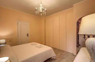 a bedroom with a white bed and a chandelier at Casa Vacanze Crispi little 2 in Rome
