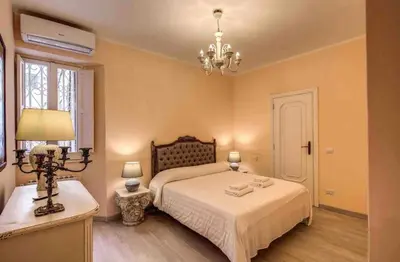 a bedroom with a bed and a chandelier at Casa Vacanze Crispi little 2 in Rome