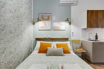 a small bedroom with a bed with orange pillows at BDC - Love nest! Small but cozy in Rome