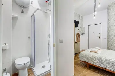 a white bathroom with a toilet and a shower at BDC - Love nest! Small but cozy in Rome