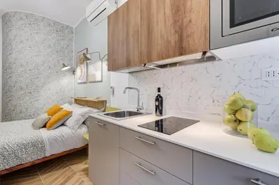a kitchen with a sink and a bed in a room at BDC - Love nest! Small but cozy in Rome