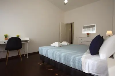 a hotel room with a bed and a desk and a chair at Villa Borghese Holiday House in Rome
