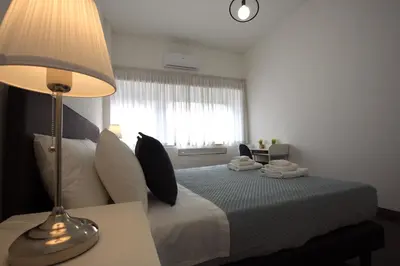 a bedroom with a bed with a lamp and a window at Villa Borghese Holiday House in Rome