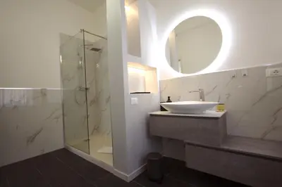 a bathroom with a sink and a shower with a mirror at Villa Borghese Holiday House in Rome