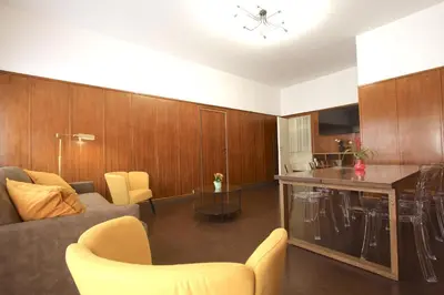 a living room with a couch and a table and a kitchen at Villa Borghese Holiday House in Rome