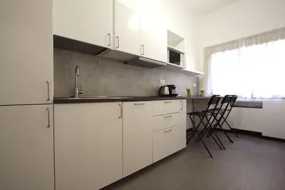 a kitchen with white cabinets and a counter top at Villa Borghese Holiday House in Rome
