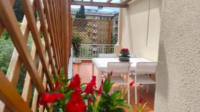 a balcony with a table and chairs and red flowers at Clivo Vaticano Rooftop in Rome
