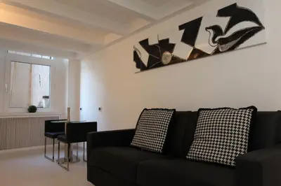 a living room with a black couch and a table at LHP Suite Roma Piazza del Popolo in Rome