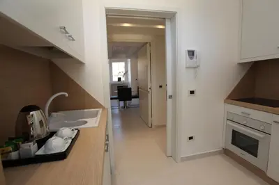 a kitchen with a counter with a sink and a hallway at LHP Suite Roma Piazza del Popolo in Rome