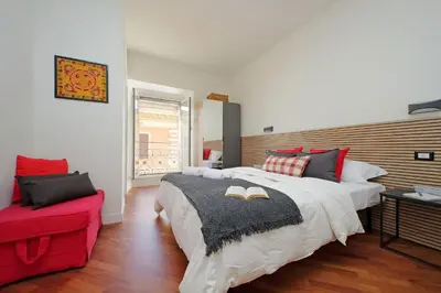 a bedroom with two beds and a red couch at Vatican apartment Leone IV - MrLucas in Rome