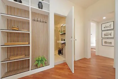 a hallway with white walls and wooden shelves at Vatican apartment Leone IV - MrLucas in Rome