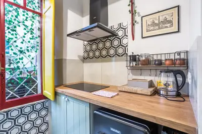 a kitchen with a counter with a sink and a window at La Piccola Retró , urban color and comfort in Rome