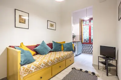 a living room with a couch with colorful pillows at La Piccola Retró , urban color and comfort in Rome