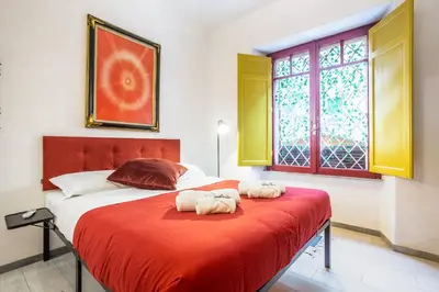 a bedroom with a bed with two towels on it at La Piccola Retró , urban color and comfort in Rome