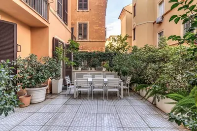 a patio with tables and chairs in a courtyard at Luxury flat with terrace by historic center in Rome