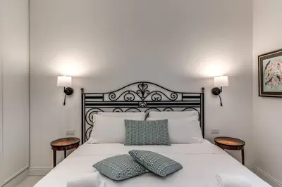 a bedroom with a white bed with two pillows on it at Luxury flat with terrace by historic center in Rome