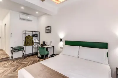 a bedroom with a white bed and a desk at Effe Luxury Rooms in Rome
