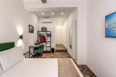 a bedroom with a white bed and a desk at Effe Luxury Rooms in Rome