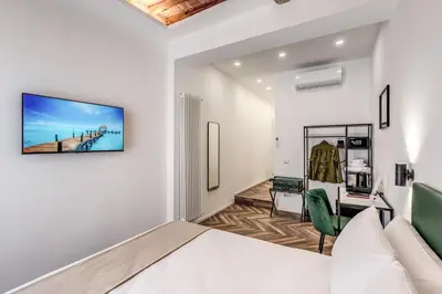 a bedroom with a bed and a desk in a room at Effe Luxury Rooms in Rome