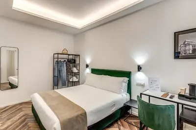 a hotel room with a bed and a desk and a bed sidx sidx at Effe Luxury Rooms in Rome