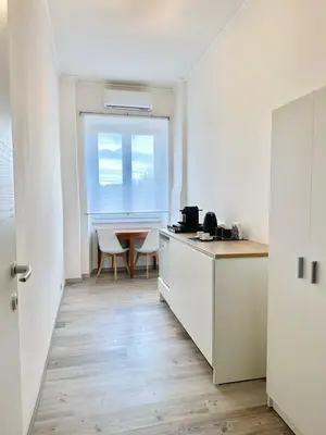 a kitchen with white cabinets and a table and a window at Rhome in Rome