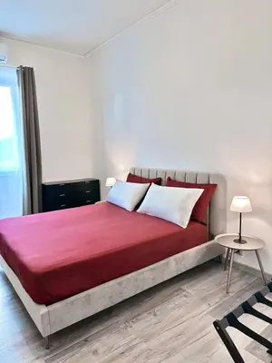 a bedroom with a large red bed with two pillows at Rhome in Rome