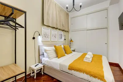 a bedroom with a large bed with yellow pillows at BDC - Central charming 2-Bdr! in Rome