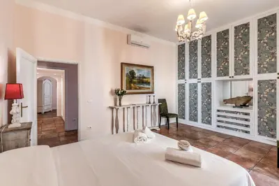 a bedroom with a white bed and a large window at Casa Vacanze Collina in Rome