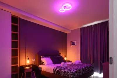 a room with a bed with a purple light at Domus Maria in Rome