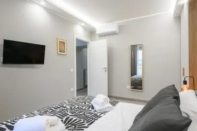 a white room with a bed and a flat screen tv at Domus Maria in Rome