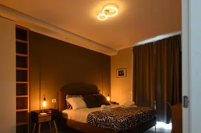 a bedroom with a bed with two lights on it at Domus Maria in Rome