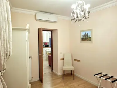 a hallway with a chair and a chandelier at Firenze 32 at the Opera House in Rome