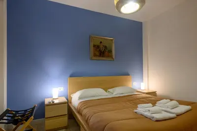 a blue bedroom with a bed with towels on it at Prosper House in Rome